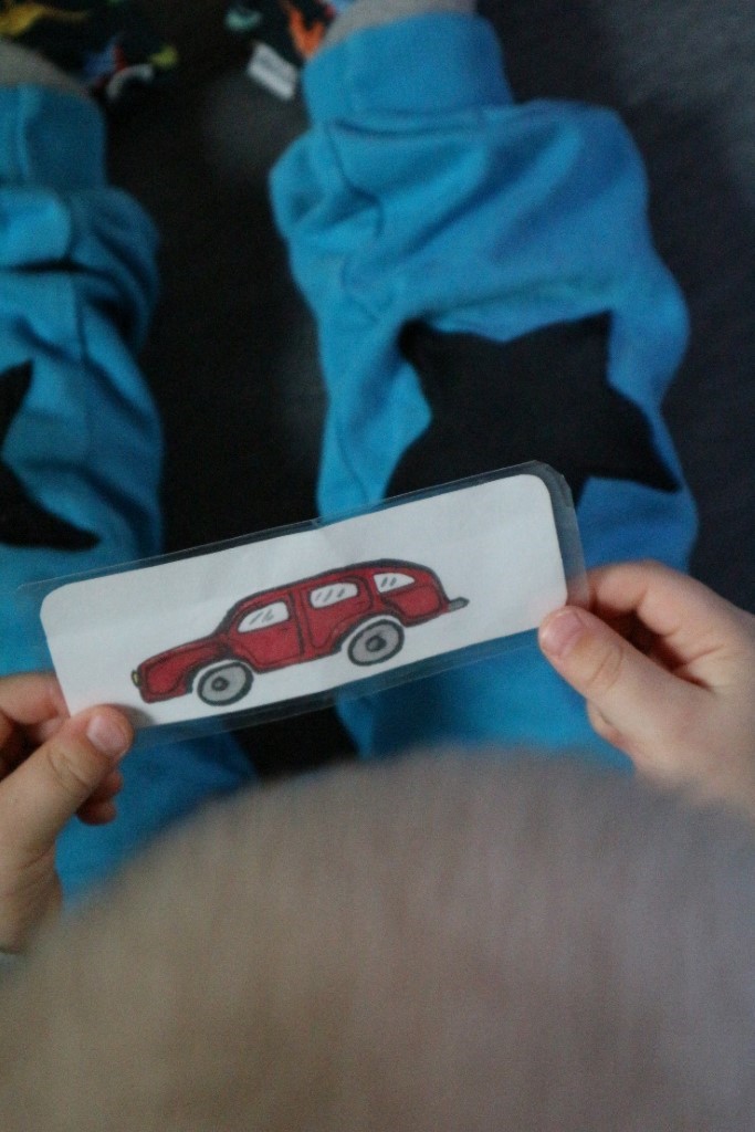 Kuvassa lapsi pitää kiinni paperista, jossa auton kuva
