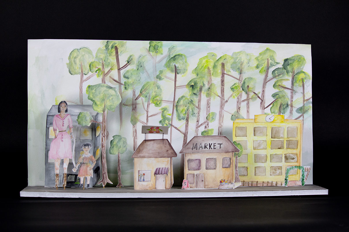 kuva 3d taideteoksesta, jossa on kylämaisema. Teoksen takaosassa on metsikköä ja edessäpäin näkyy keltainen koulu, kukkaputiikki ja kauppa. Teoksen vasemmassa laidassa on äitihahmo vaaleanpunaisessa mekossa ja lapsi persikan värisessä mekossa.