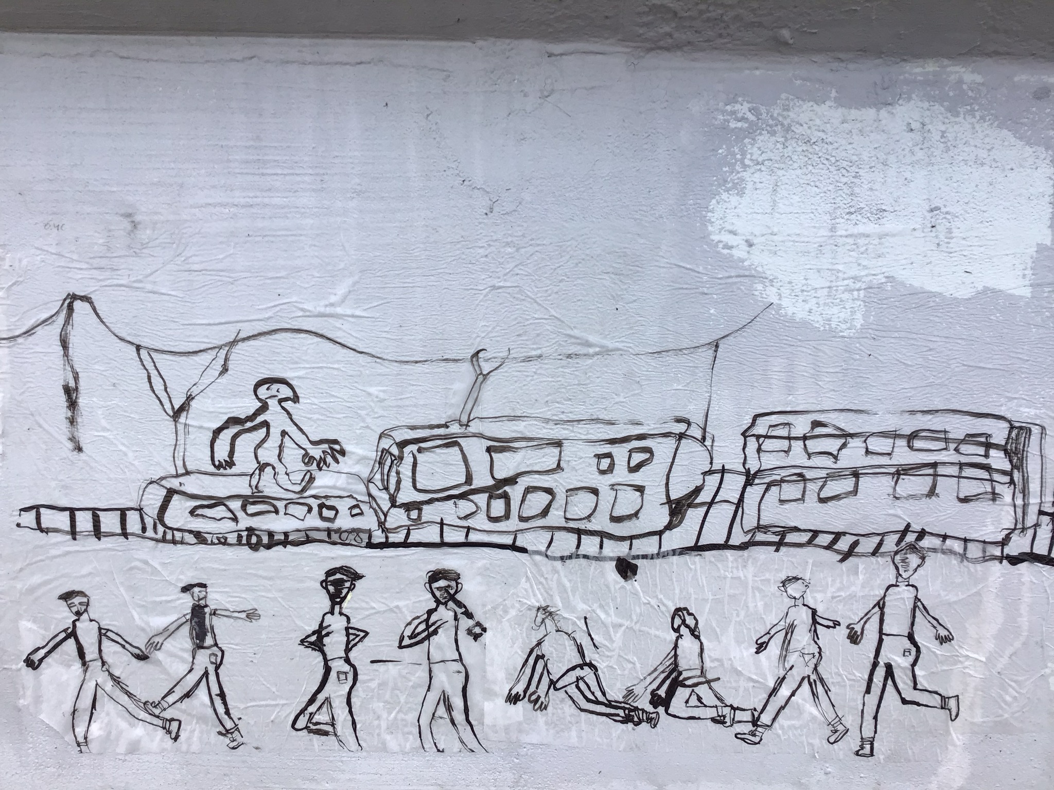 Lähikuva oppilaiden teoksista sillan kaiteessa. Kuvassa juna kiskoilla sekä ihmishahmoja