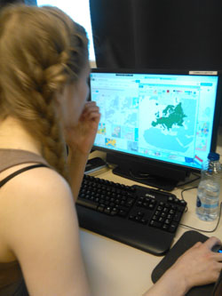 Opiskelija tutkii maantiedon karttoja netissä