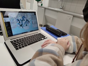 Opiskelija tutkimassa karttaa tietokoneen avulla