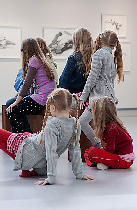 Tässä kuvassa koululaiset istuvat Taidemuseossa.