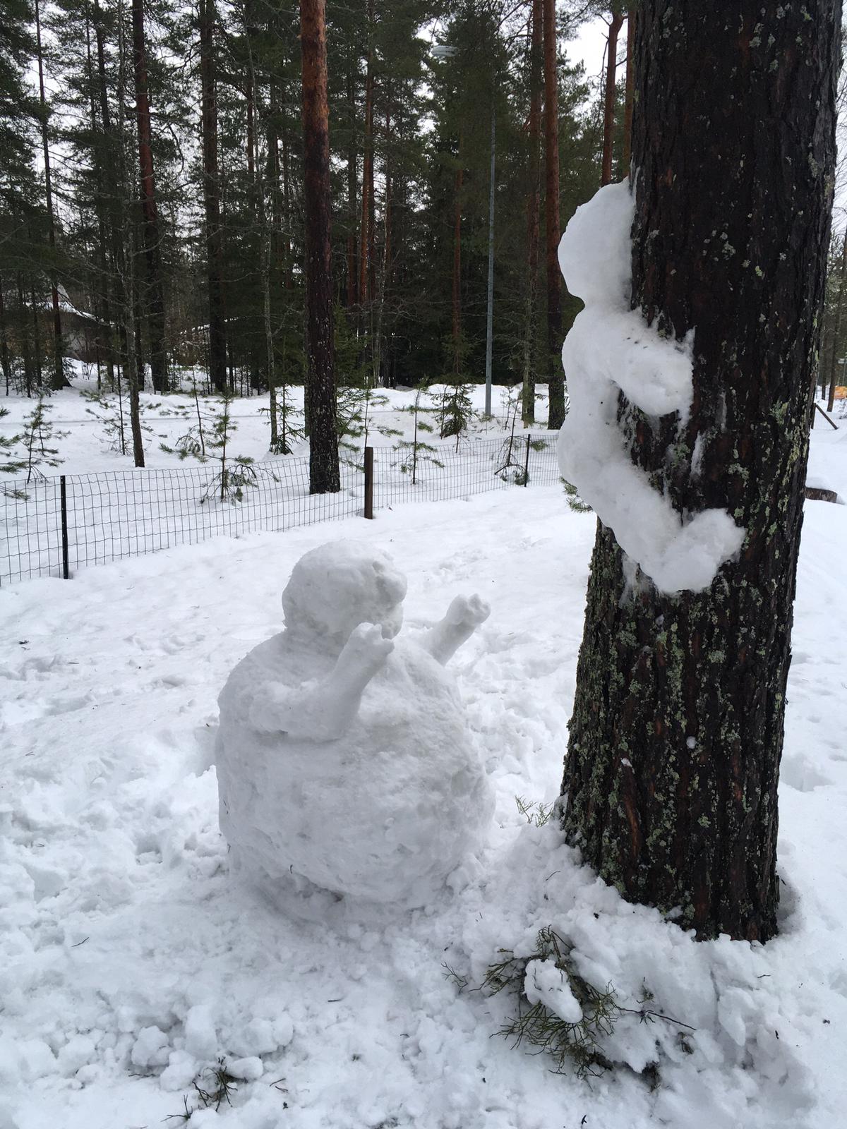 Luminen hahmo puunrungossa ja toinen hahmo kädet ojossa ensimmäistä hahmoa kohti.