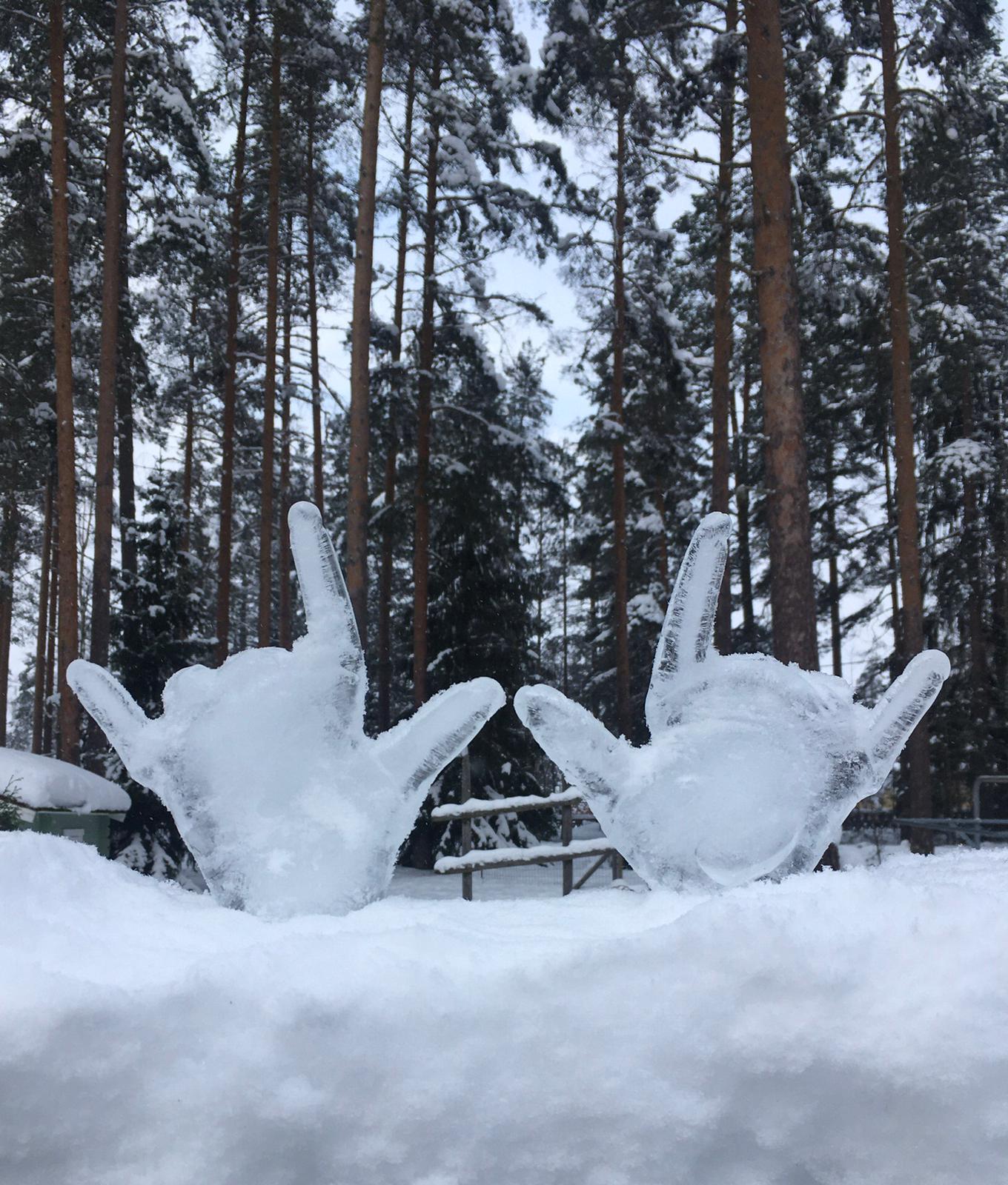 Kaksi jäädytettyä kättä lumihangessa.