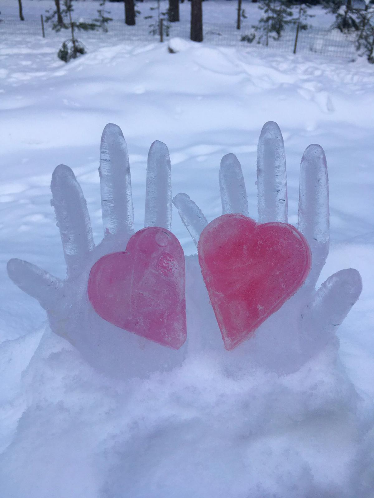 Kaksi jäädytettyä kättä, joissa on sydämet.