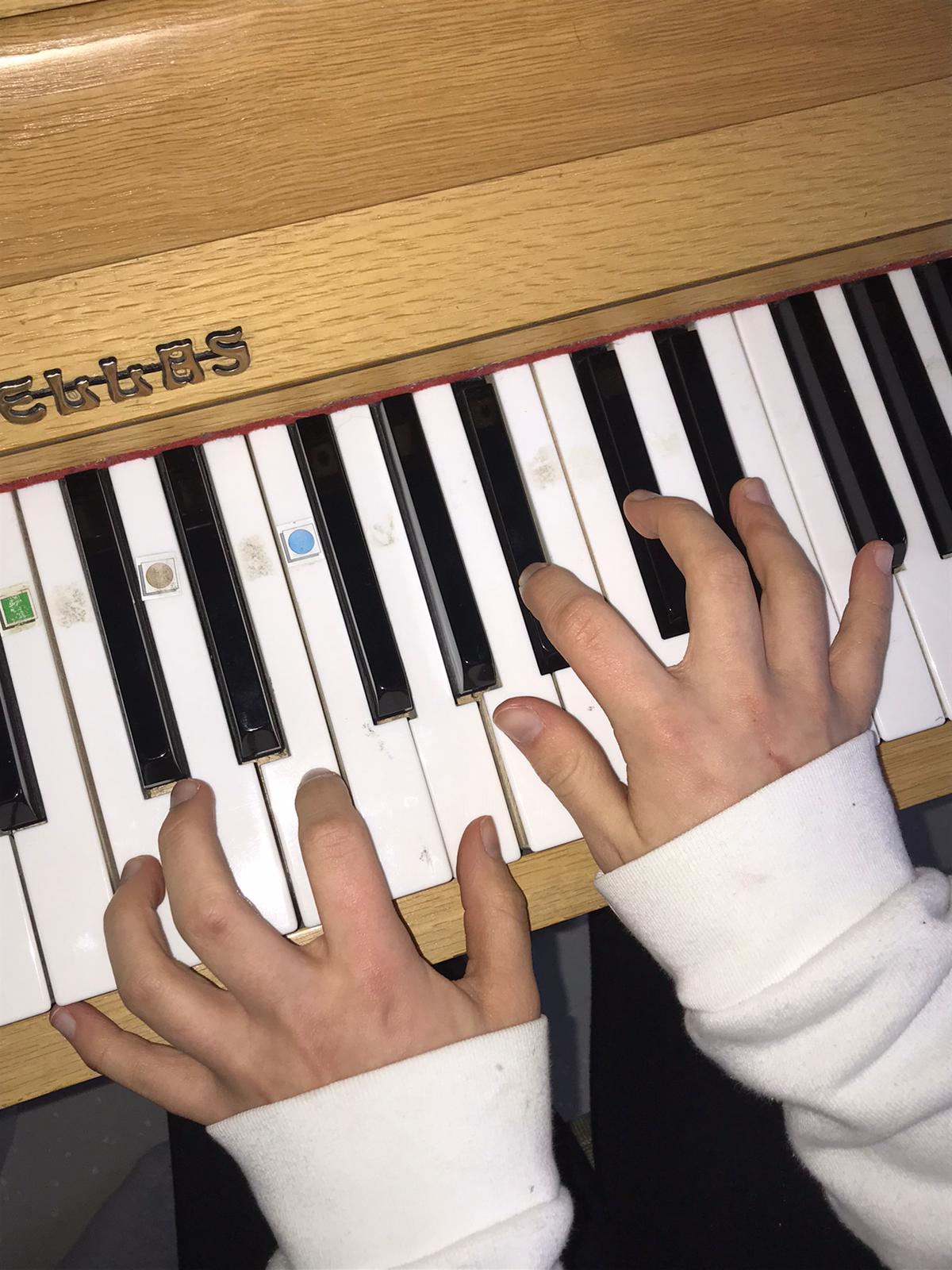 Kuvassa sormet pianolla