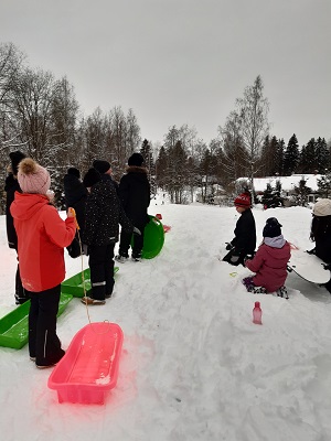 Oppilaita jonottamassa pulkkamäessä