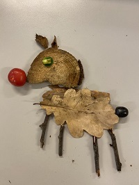 koira rakennettuna puiden lehdistä