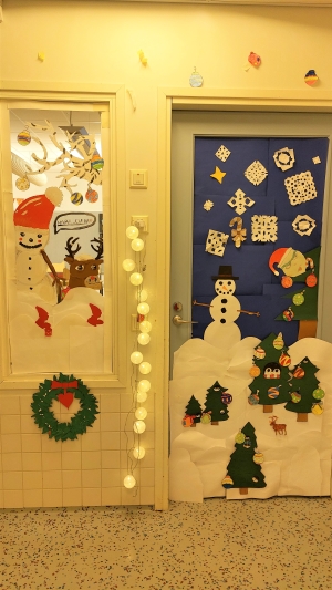 lumiukko ja lumihiutale koristeita luokan ovessa ja ikkunassa
