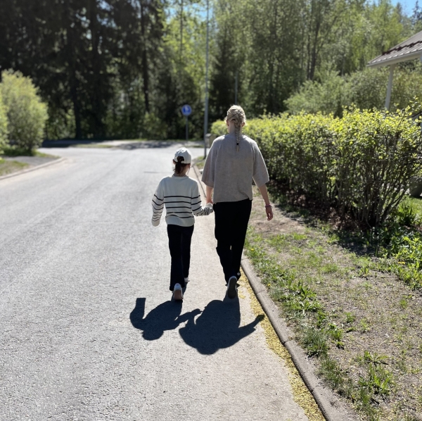 yläkoululainen ja alakoululainen kävelevät käsikädessä