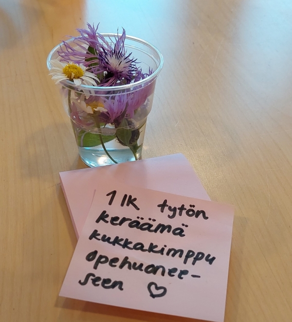 pieni kukkakimppu opettajanhuoneen pöydällä