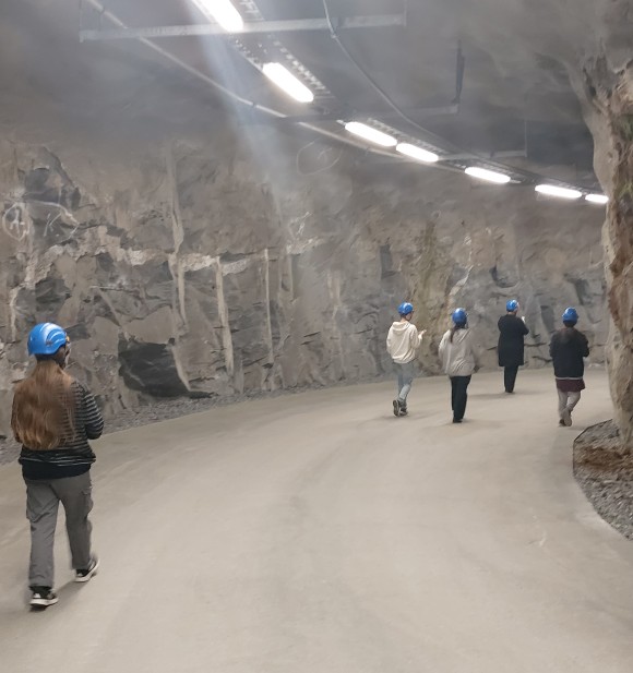 oppilaita kulkemassa kallioluolassa