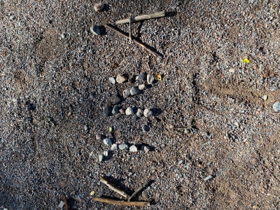 kivistä maahan kirjoitettu teksti kynä