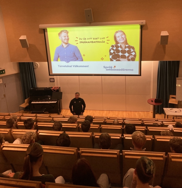 sprakambassador puhuu oppilaille auditoriossa
