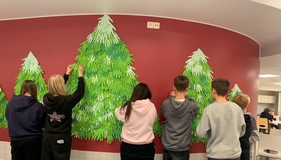 oppilaita ripustamassa töitä seinälle