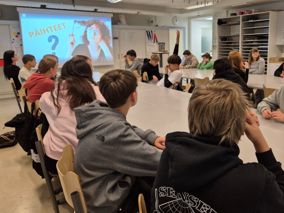 oppilaat katsomassa powerpoint-esitystä ja viittaamassa