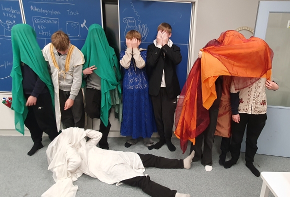 oppilaat luokan edessä rooliasuissa