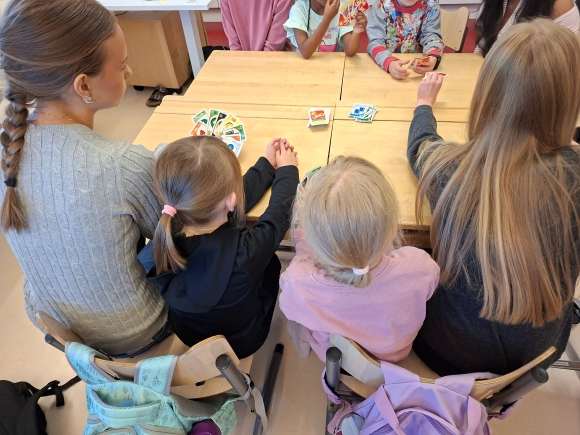ysejä ja ykkösiä pelaamassa pöydän ääressä