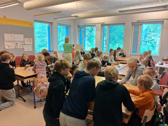 ysit ykkösten kanssa luokassa opettaja seuraa mukana