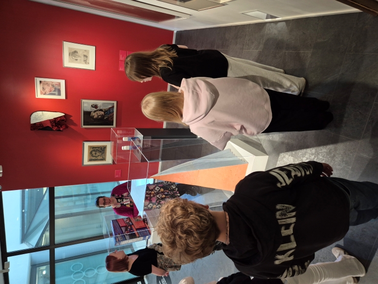 museo-opas ja oppilaita tarkastelemassa taideteoksia