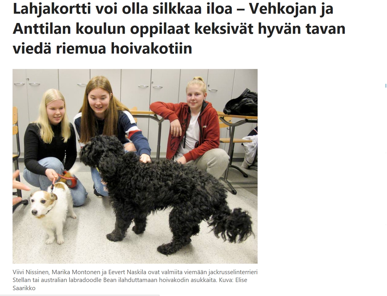 Kuvassa koira ja oppilaita sekä teksti: Lahjakortti voi olla silkkaa iloa - Vehkojan ja Anttilan koulun oppilaat keksivät hyvän tavan viedä riemua hoivakotiin