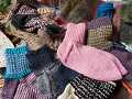 Kuvassa kasa värikkäitä villasukkia, päällimmäisenä vaalenapunainen sukka