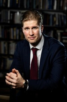 Kuvassa on Henri Vanhanen tummassa puvussa.