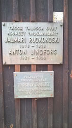 Kuvassa puuseinään kiinnitetty Ruokokosken ja Lindforssin muistolaatta