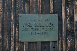 Kuvassa puuseinässä oleva Tyko Sallisen muistolaatta, jossa lukee taidemaalari Tyko Sallinen asui tässä talossa  1916-1950