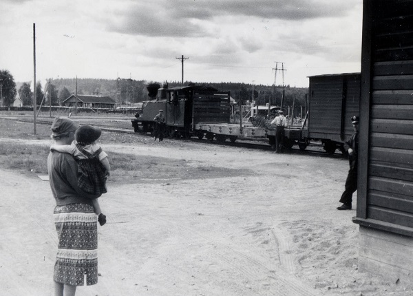 Tässä kuvassa äiti ja lapsi katselevat junavaunua.