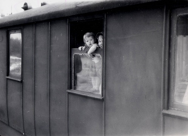 Tässä kuvassa lapsi kurkistaa junan ikkunasta.