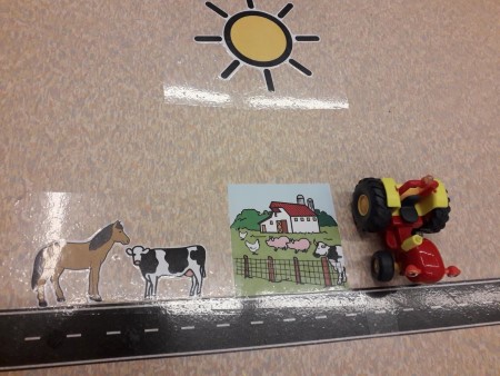 autoleikin lähikuva jossa maatila, hevonen, lehmä, trakstori ja aurinko