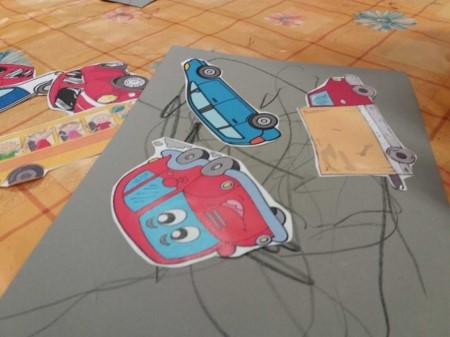 kuvassa harmaalle paperille lasten piirtämiä autoteitä
