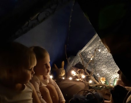 lapset istuvat hämyisessä teltassa päiväkodin sisällä