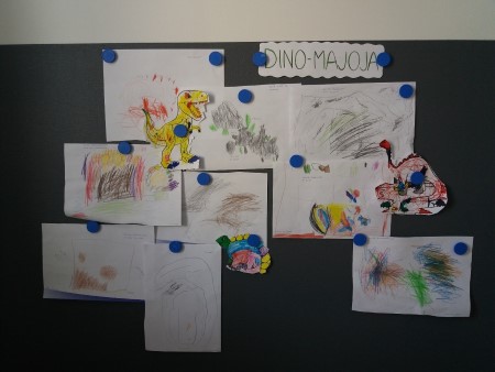 kuva seinästä jossa on lasten tekemiä dinosauruspiirroksia