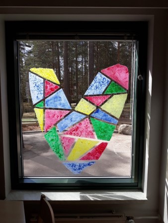 kuvassa on eri värein maalattu sydän ikkunaan