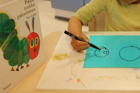 lapsi piirtää kirjasta "Pikkutoukka paksulainen"