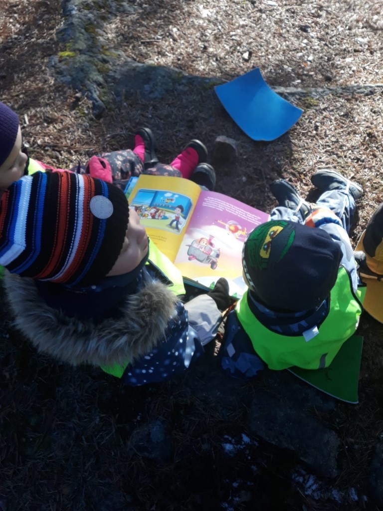 kuvassa lapset katsovat kirjaa
