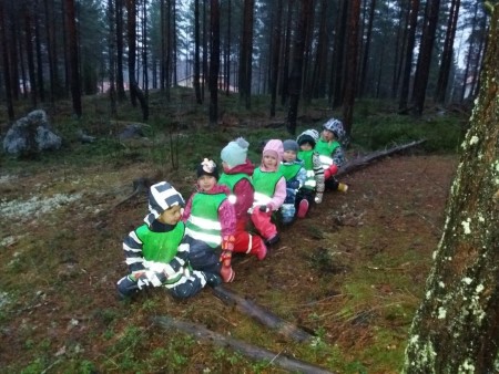 lapset istuvat jonossa metsässä