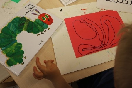 lapsi piirtää toukan kuvaa mallina kuvakirja "Pikku toukka paksulainen"